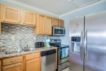 Renovated kitchen with stainless steel appliances and tiled backsplash